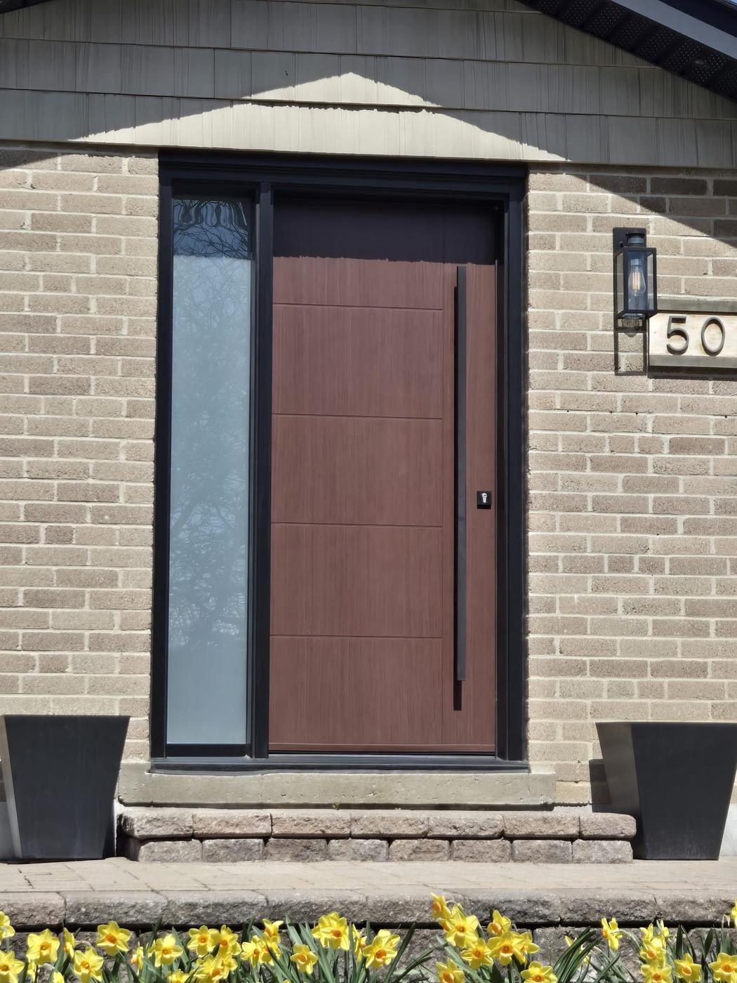 Modern woodgrain fibreglass entrance door with frosted sidelite and full-height black pull handle, typical of contemporary Vaughan home exteriors