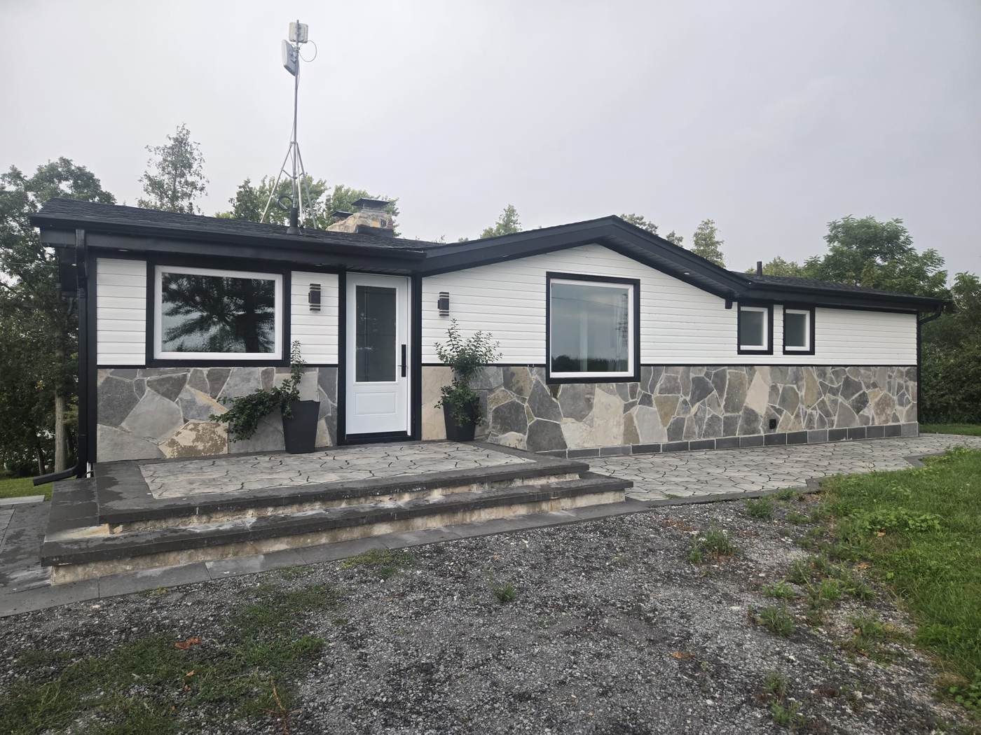 Renovated bungalow with new vinyl windows, black trim and a glazed entrance door, typical of the housing stock across south Mississauga