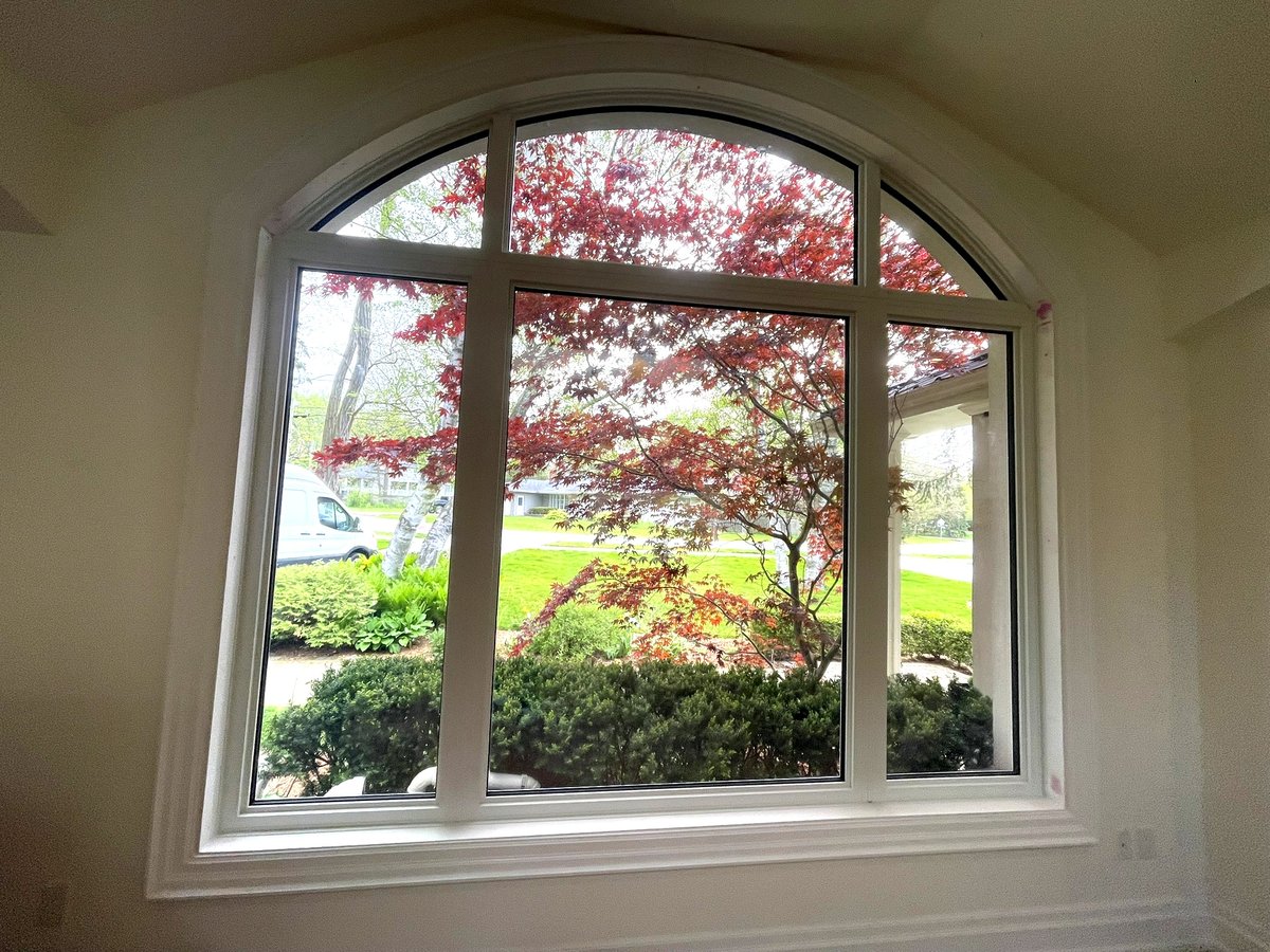 Interior view of an arched picture window with a garden view